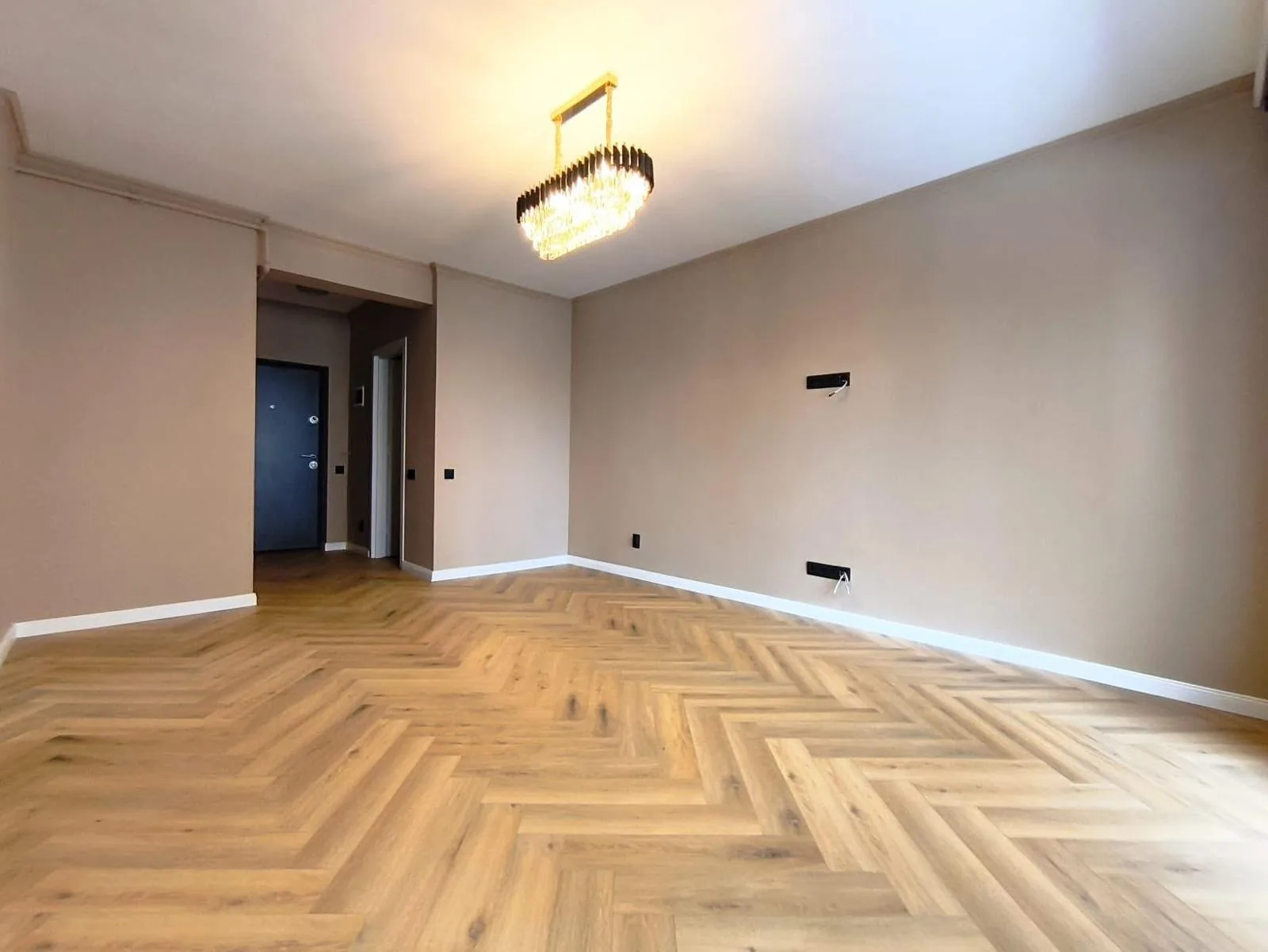 Oak herringbone flooring fitted across a finished reception room