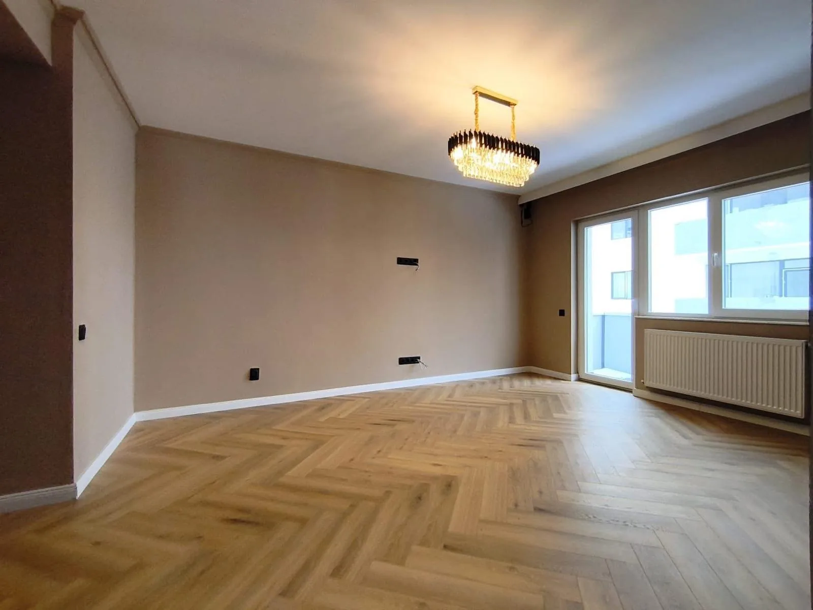 Finished oak herringbone floor across a bright reception room