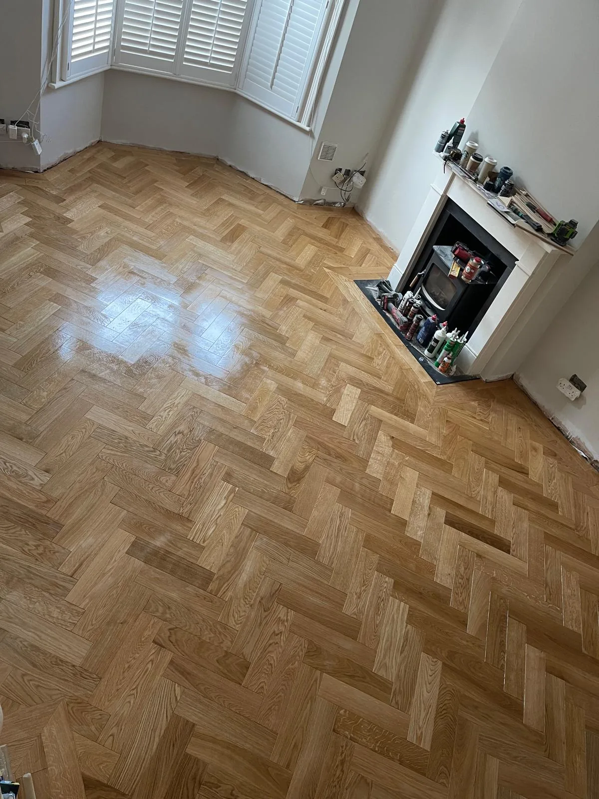 Restored oak parquet flooring in a period room with a fireplace